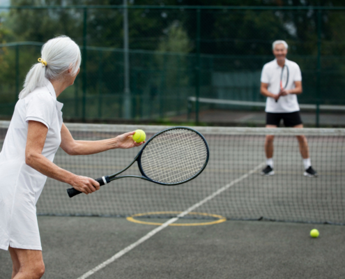 Twee mensen zijn aan het tennissen en hebben last van een tennisarm