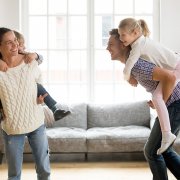 Vrolijk gezin is in de woonkamer aan het spelen zonder rugklachten