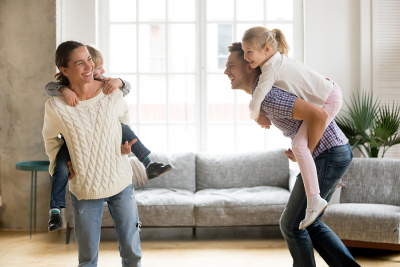Vrolijk gezin is in de woonkamer aan het spelen zonder rugklachten