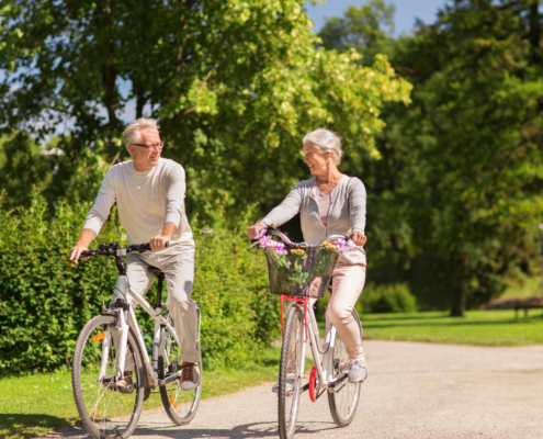 Man en een vrouw in hun pensioen blijven fit door te gaan fietsen in een park.