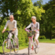 Man en een vrouw in hun pensioen blijven fit door te gaan fietsen in een park.