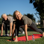 Man en een vrouw met artrose zijn bezig met stretchoefeningen in het park.