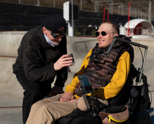 Man met ALS zit in een rolstoel te genieten van de zon.